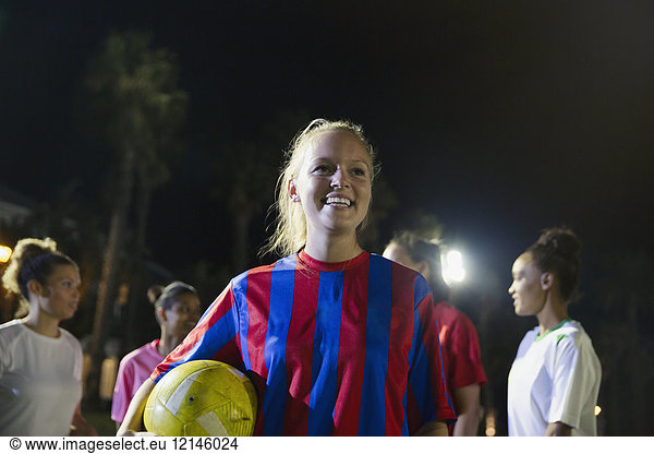 Portrait smiling  confident young female soccer player with ball
