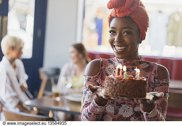 Portrait smiling  confident young woman holding birthday cake with candles