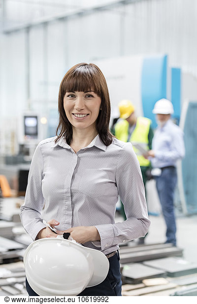 Portrait smiling engineer with hard-hat in factory