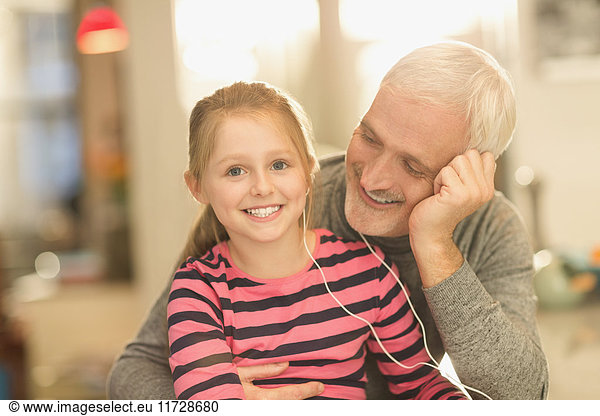 Portrait smiling father and daughter bonding  sharing headphones  listening to music