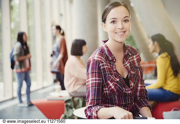 Portrait smiling female college student in commons