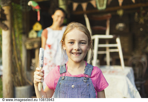 Portrait smiling girl holding paintbrush