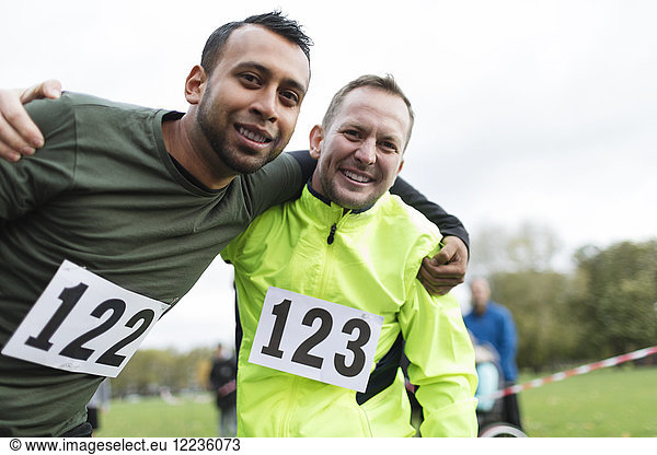 Portrait smiling male marathon runners hugging