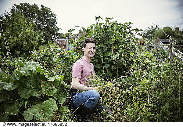 Portrait smiling man gardening in backyard garden