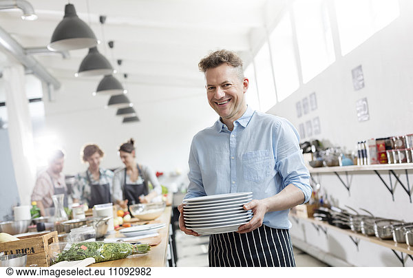 Portrait smiling man in cooking class kitchen