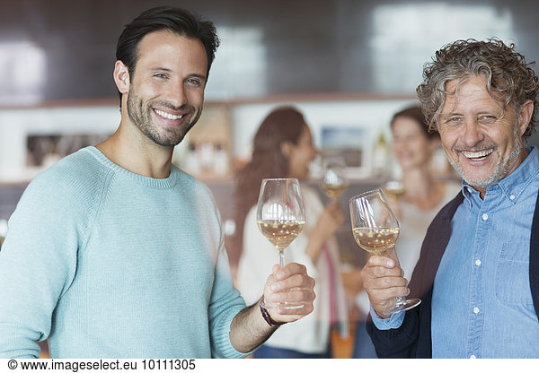 Portrait smiling men wine tasting at winery tasting room