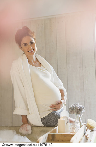 Portrait smiling pregnant woman preparing bubble bath