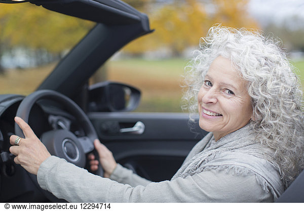 Portrait smiling senior woman driving convertible