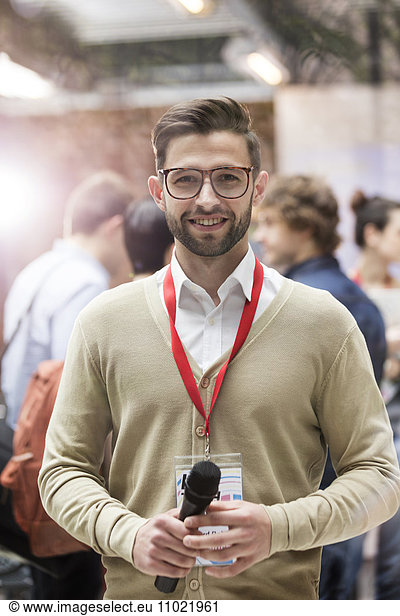 Portrait smiling speaker with microphone at technology conference