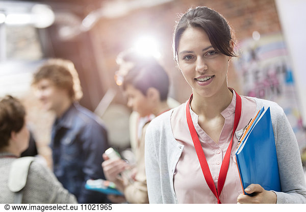 Portrait smiling woman holding folder at technology conference