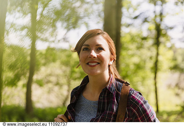 Portrait smiling woman with red hair hiking in woods