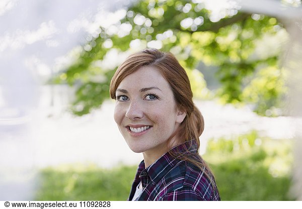 Portrait smiling woman with red hair outdoors