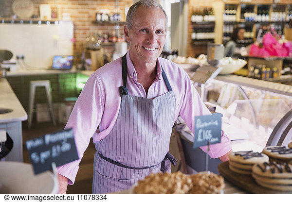 Portrait smiling worker behind desserts in market