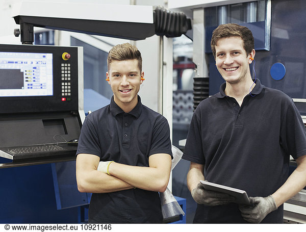 Portrait smiling workers with digital tablet in steel factory