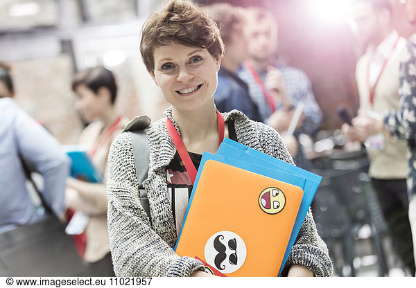 Portrait smiling young woman with laptop at technology conference