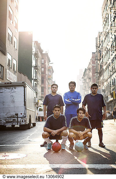 Portrait soccer players standing at city street