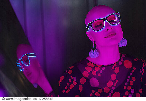 Portrait stylish serene woman in neon eyeglasses