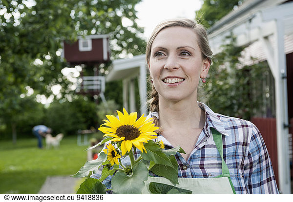 Portrait woman holding sunflower smiling