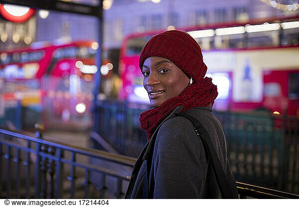 Portrait young woman in red hat and scarf on city sidewalk  London  UK