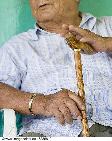 Portraits of a farm worker at his home in Oaxaca  Mexico. Holding his cane.