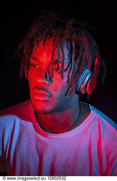 Portraits of beautiful African young man under blu and red lights