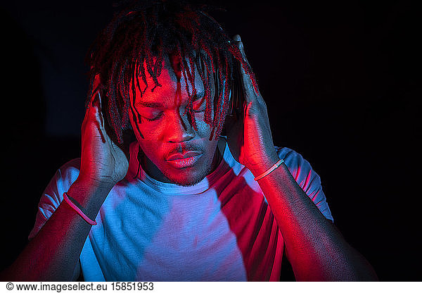 Portraits of beautiful African young man under blu and red lights