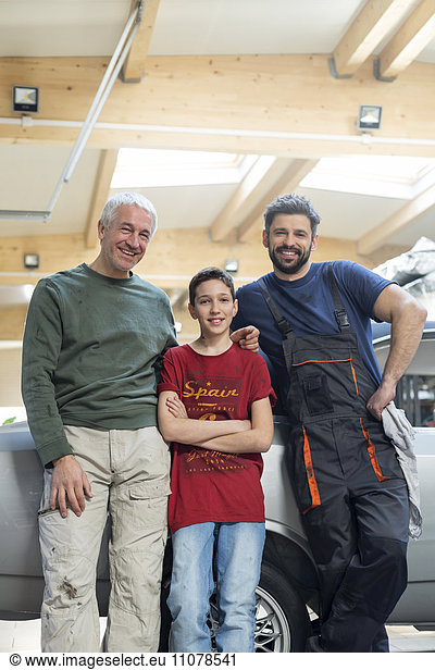 Portraits smiling multi-generation mechanic family in auto repair shop