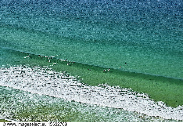 Portugal,  Algarve,  Arrifana,  People surfing in green coastal waters