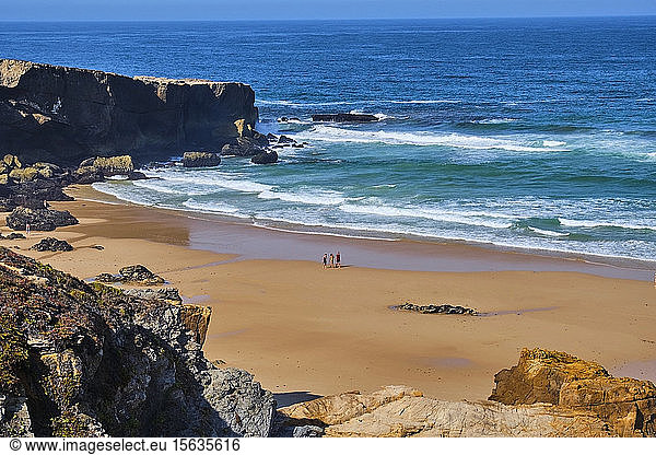 Portugal  Alentejo  Vila NovaÂ deÂ Milfontes  Drei Personen  die im Sommer am Strand von MalhaoÂ spazieren gehen