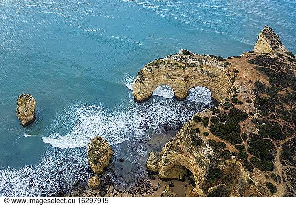 Portugal  Algarve  Lagoa  Drohnenblick auf das türkisfarbene Wasser des Atlantiks und den Felsbogen an der Küste