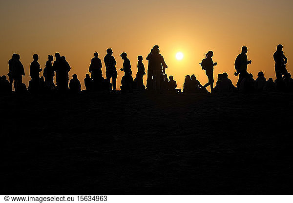 Portugal  Algarve  Silhouettes of people relaxing against setting sun at Cape Saint Vincent