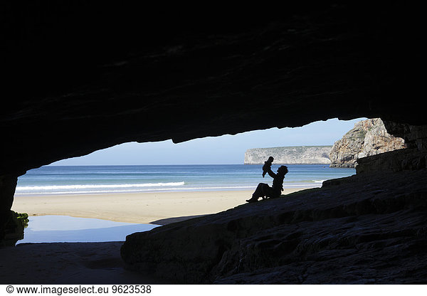 Portugal  Cape St. Vincent  Silhouette of mother and child in cave