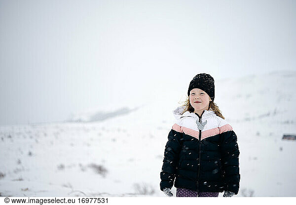 Positive cute kid enjoying winter day in mountains