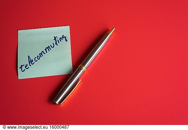 Post-it with a pen on red background.