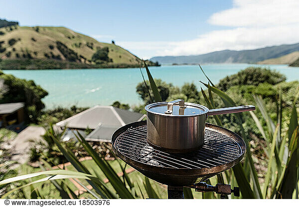 Pot with lid on a small grill with scenic view