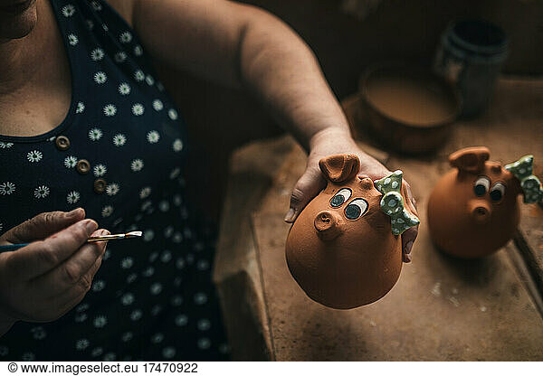 Potter making clay decoration at workbench in pottery