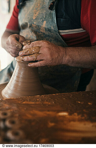 Potter shaping clay in pottery