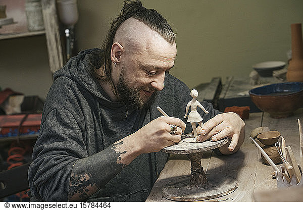 Potter working on a tiny figurine in workshop