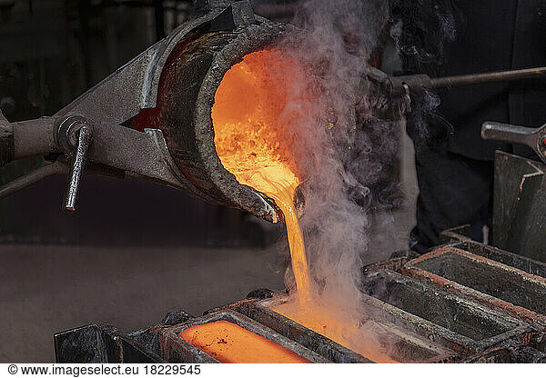Pouring ingots of brass in brass foundry