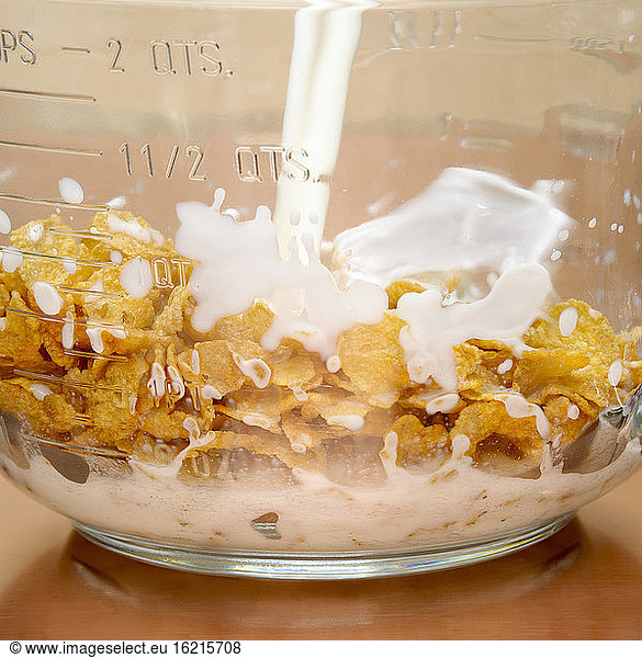 Pouring milk over cornflakes  close-up