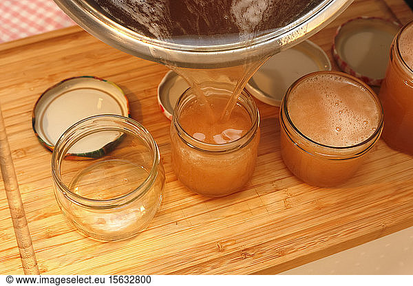 Pouring quince jelly into jars