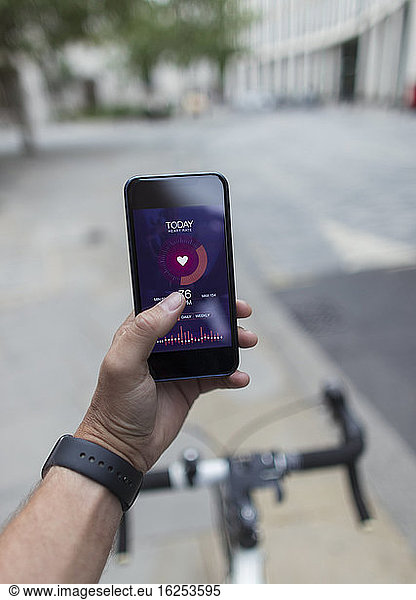 POV Man on bicycle using smart phone health app