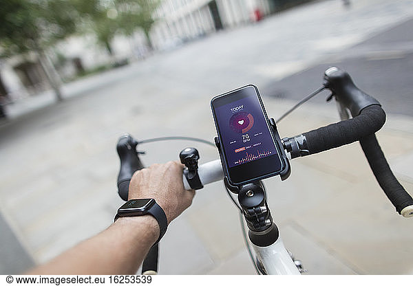 POV man riding bicycle with smart phone health monitor