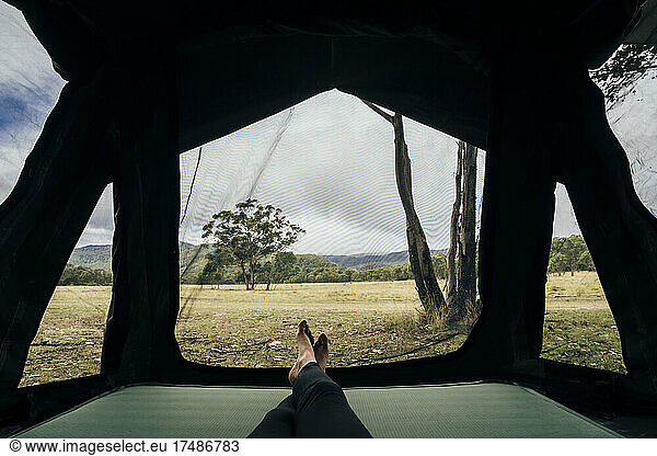 POV woman relaxing inside tent in remote Australian bush