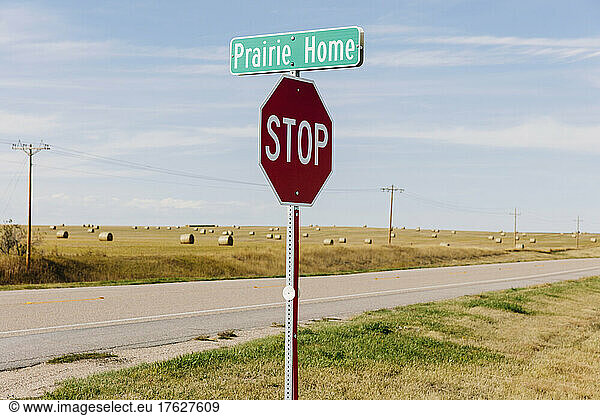 Prairie Home sign and stop sign at the side of a road.