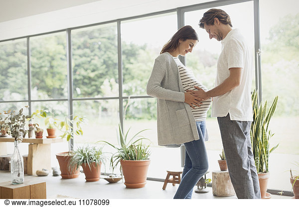 Pregnant couple holding stomach