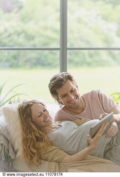 Pregnant couple using digital tablet