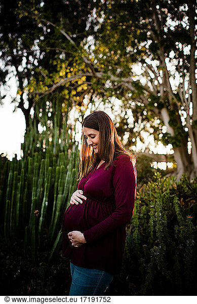 Pregnant Mid Thirties Woman Standing in Garden at Sunset in San Diego