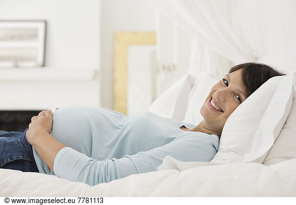 Pregnant woman laying on bed