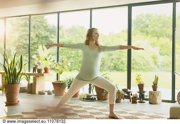 Pregnant woman practicing yoga warrior 2 pose